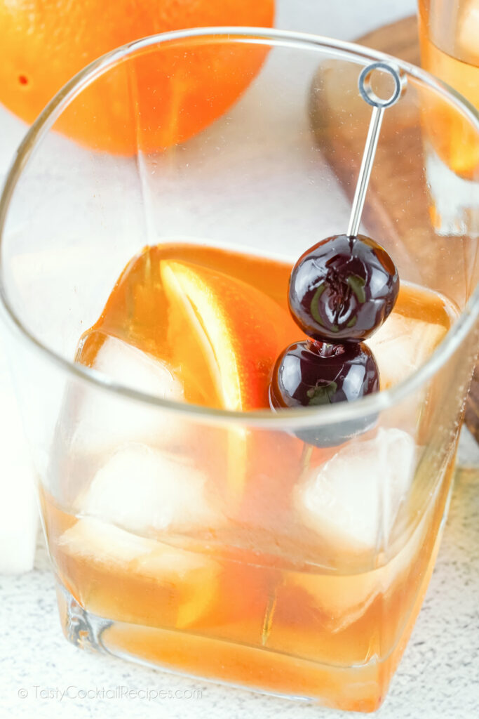 old fashioned cocktail with bourbon, orange, and cherries
