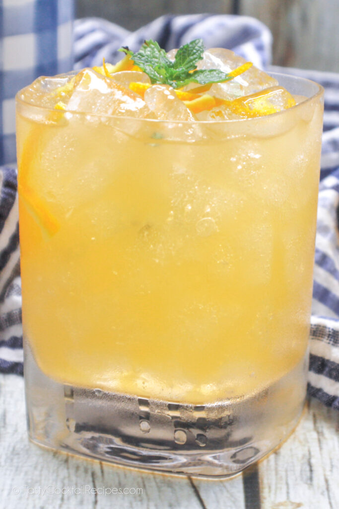 Side view of an Orange Whiskey Smash cocktail
