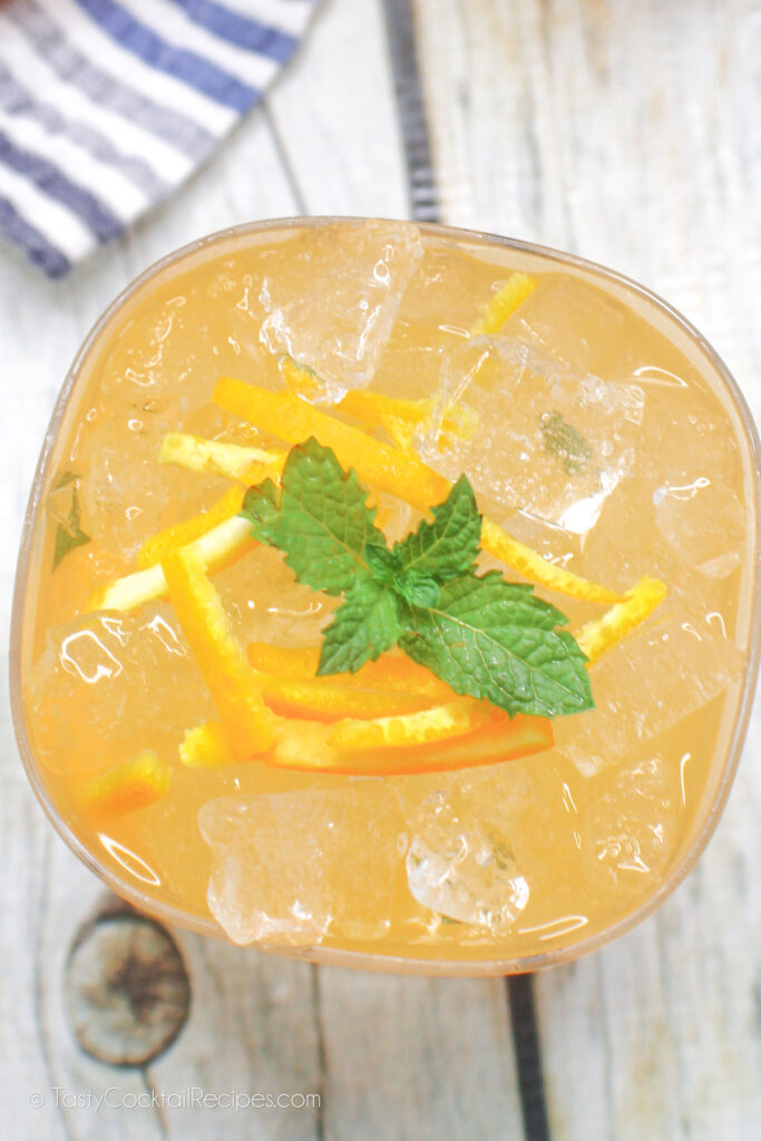 Top Down View of Orange Whiskey Smash drink with mint and orange rind