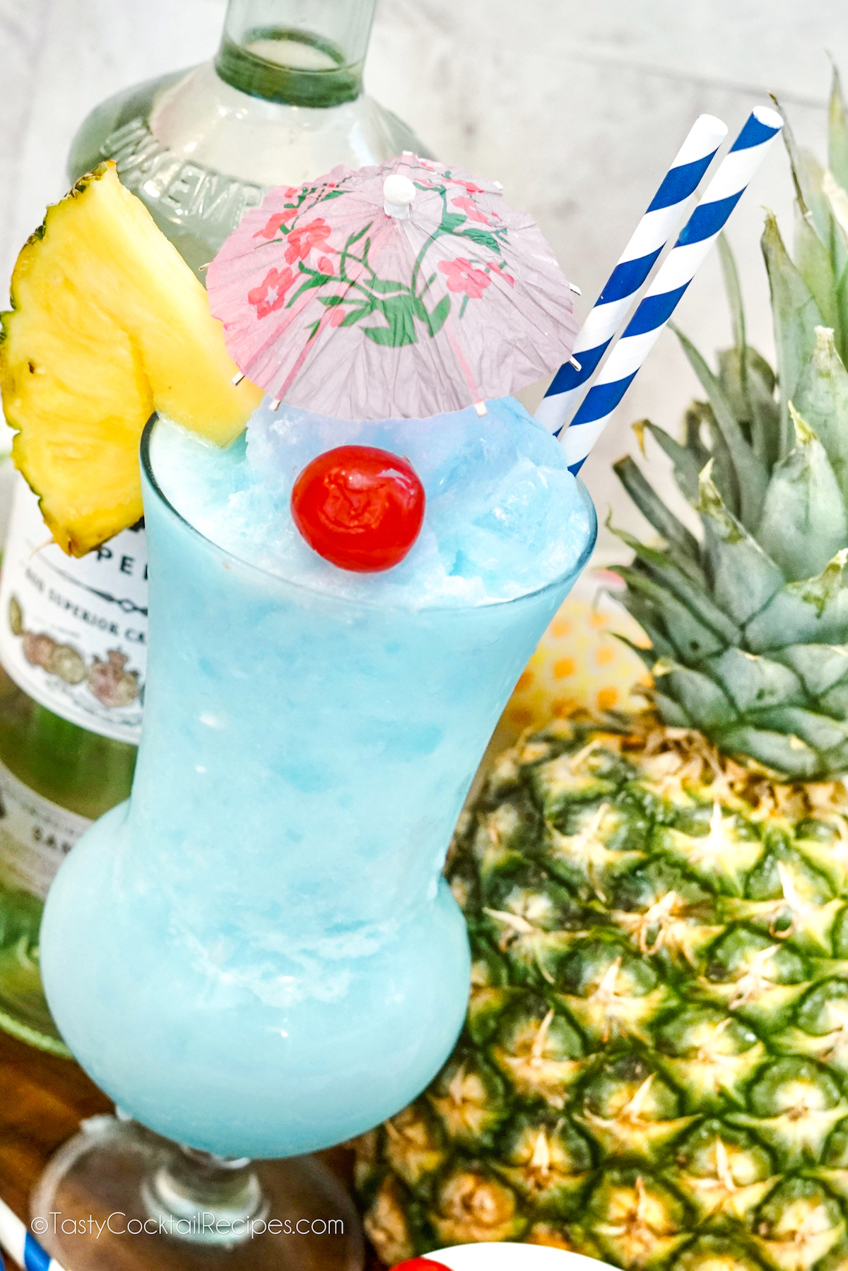 frozen Blue Hawaiian tropical drink in hurricane glass with fruit and paper umbrella